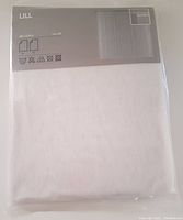 Front view of packaged white sheer lace curtain panel, showing label with sizing and care instructions.