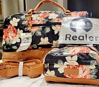 Overall lot showing floral weekender bag, toiletry bag, reusable fabric shopping bag, and tan strap, all new with tags.