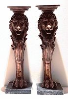 Front view of both bronze lion candle holders showing detailed lion faces and bases.