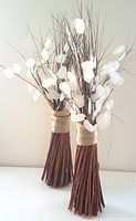 Two twig foliage bunches each with a bundle of thin brown twigs tied with natural twine, featuring white translucent round leaves.