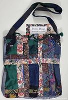 Front view of patchwork fabric oversize bag with floral label inside.