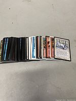 Stack of assorted Magic The Gathering cards showing fronts with artwork and text.
