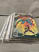Side shot of stacked comic books in protective sleeves showing one Action Comics cover
