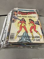 Stack of assorted comic books featuring Spider-Woman cover and other assorted issues in protective sleeves.