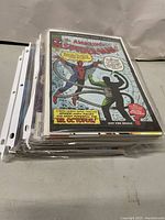 Stack of assorted comic books with The Amazing Spider-Man #3 on top in plastic sleeves