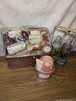 Full view of three NOS bath and beauty gift sets showing packaging and products with some wear present