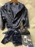 Front view of the boys V & Grin hooded robe size 7-8 in dark gray plush fabric, hanging on a hanger. Two unopened 6 packs of Adidas socks adjacent to the robe.