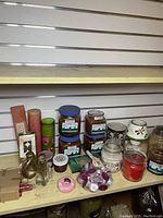 Full lot image showing assorted candles and home fragrance items, including jar candles, pillar candles, tealight candles, candle warmer, and glass bottle decorations.
