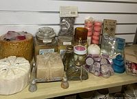 Wide view showing assortment of candles, wax melts, tea lights, and fragrance items arranged on a shelf