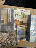 Photo showing Crayola Colored Pencils 50 colors, PopSockets PopWallet+, floral pattern notebooks, Pentel pencil set in plastic case, and stacked ACCO A-Z Tabs boxes.