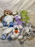 Full view of the plush toy assortment showing all seven plush items arranged together