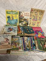 Overview of the vintage children's book assortment showing multiple titles including Sesame Street Library, Fairy Tales, Charlotte's Web and others.
