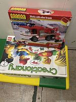 Photo showing LEGO lap tray table with boxed Best-Lock fire engine set and Creationary board game stacked on top