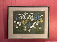 Framed green flower crewel embroidery on dark green fabric with glass front and beige matting, capturing full artwork size and framing condition