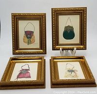 Group photo showing three framed watercolor paintings of purses by Peggy Abrams. Two paintings upright on stands, two paintings lying flat.