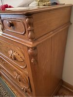 Close-up side angle of walnut dresser showing smooth wood finish, rounded edges, and carved vertical columns