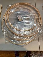 Photo of a set of five wooden embroidery hoops wrapped in plastic.