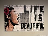 Frontal view of the extra large gallery-wrapped canvas print depicting a woman singing and the text 'Life is Beautiful' in stencil graffiti style on a white brick wall background