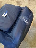 Folded dark blue inflatable hot tub with SaluSpa Hawaii logo and lot number tag.