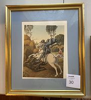 Framed print of Saint George slaying the dragon with a blue mat and gold frame.