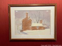 Framed watercolor painting of a brick building with snow and bare trees, taken front view against red wall.