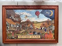 Framed watercolor painting titled "Mother Goose" depicting a village scene with autumn colors and a child in a pumpkin, signed by Robert Miller in 1993.