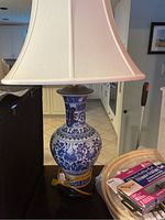 Blue and white ceramic lamp with white shade on black base