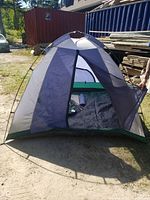 Front view of the dome-style camping tent showing zippered mesh entrance open with inner camping tent body visible.