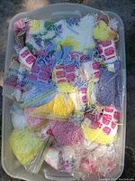 Large tub filled with various skeins of colorful Mary Maxim rug yarn packing tight inside