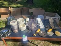 Overview of kitchenware including food processor components, glass bowls, cupcake tray, and utensils.