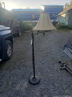 Full view of the stand up corner lamp showing the fabric lampshade with hanging bead accents and the metal stand base.