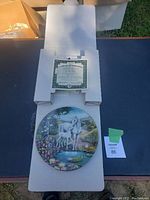 Plate in open cardboard packaging with certificate of authenticity on top.