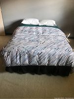 Front view of made bed with comforter and pillows visible