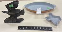 Photo of two Frankoma ceramic dishes and a soapstone bird carving together with measuring tape showing sizes.