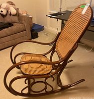 Side profile photo showing the rocking chair with bentwood frame and cane seat/back.