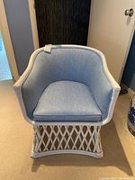 Front view of the white painted rattan chair with light blue upholstery on back and seat cushion.