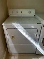 Front view of white Maytag dryer showing door and exterior finish