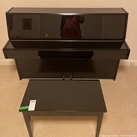 Front overview of closed piano with bench in front