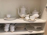 Full set display on two shelves showing pots, cups, saucers and plates