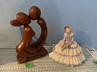 Photo showing an 8-inch tall carved wood abstract figurine alongside the Royal Doulton porcelain figurine.