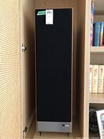 Front view of one speaker showing black grille, walnut veneer cabinet, metal base with Paradigm Monitor Series plaque