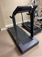 Treadmill angled view showing flat control panel and running belt.