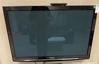 Front view of the Panasonic flat screen TV showing the overall condition and screen size.