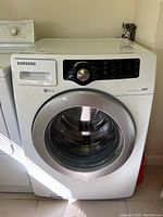 Full front view of the Samsung front-load washing machine showing door, control panel and overall condition