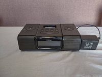 Front view of the black Apple iHome stereo docking station with attached power adapter on the right side.