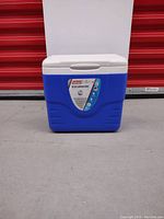 Front view of Coleman Excursion cooler showing the blue base, white lid, and capacity label on the front.