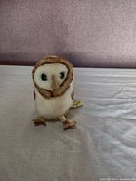 Front view of small plush owl finger puppet showing detailed face, fur, and eyes.