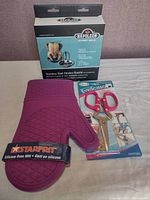 Photo of three kitchen items: silicone oven mitt, multi-purpose scissors, and chicken roaster box