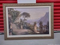 Front view of large framed canvas print showing classical outdoor scene by lake with trees and mountain in background.
