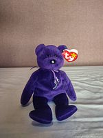 Front view of the purple Princess Diana Princess Beanie Baby bear with Ty heart tag visible on ear, sitting upright.